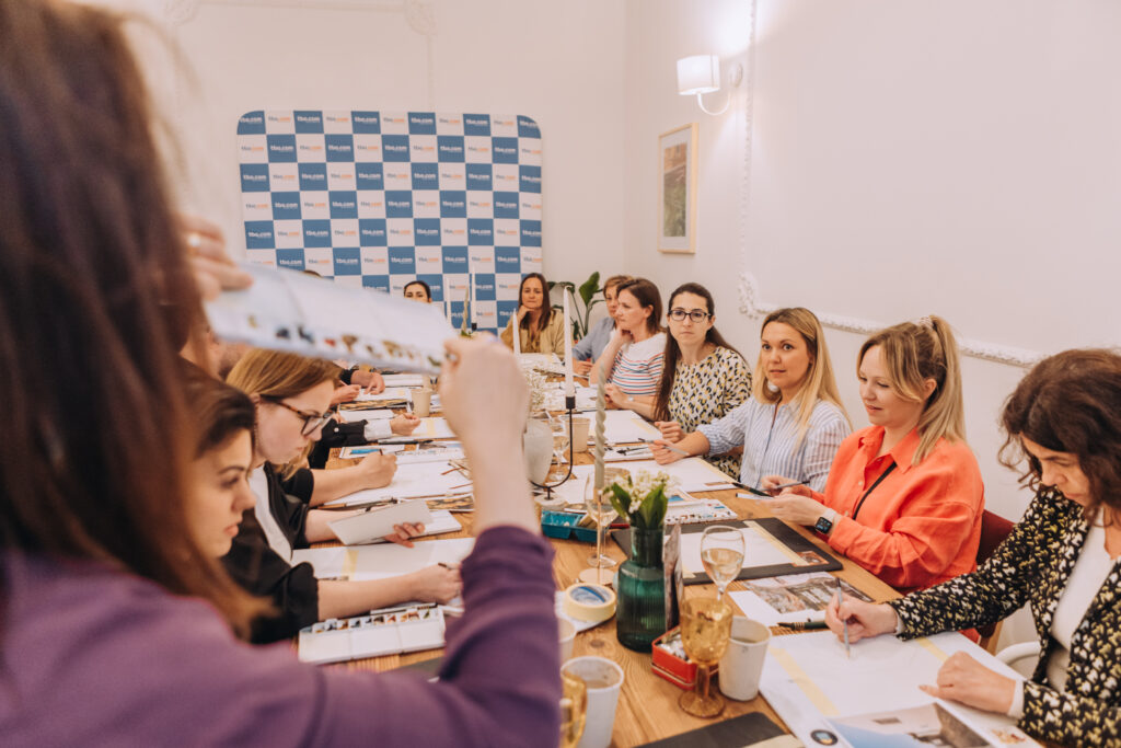 Artystka Agamoleda wspiera uczestnika warsztatów akwareli – kreatywne warsztaty integracyjne dla zespołu